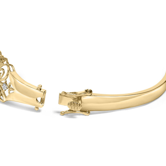 Close-up front angle of an open yellow metal bracelet clasp with part of the bracelet visible, featuring a decorative section with white round gemstones in prong settings.