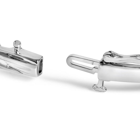 Close-up front angle of a white metal bracelet clasp with shared prong-set round black and white gemstones.