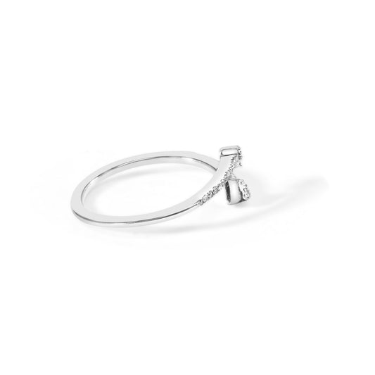 White metal ring with a curved band featuring small round white gemstones in prong settings along one side, photographed from a slight side angle on a white background.