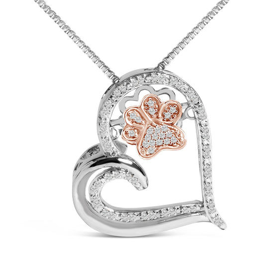 Close-up front angle of a heart-shaped necklace pendant with white and rose metal colors featuring round white gemstones in prong settings, including a rose-colored paw print design inside the heart, shown against a white background.