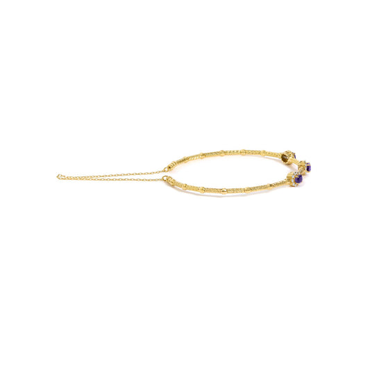 Yellow bracelet with textured and smooth sections, featuring clusters of oval purple gemstones surrounded by small round white gemstones in prong settings, shown flat on a white background from a top angle.
