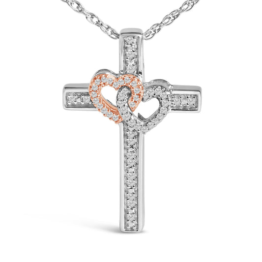 Close-up front view of a necklace pendant featuring a cross with two interlocking heart shapes adorned with white gemstones in a pave setting, one heart outlined in rose metal color and the other in white metal color.