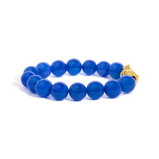 Close-up front angle of a yellow metal bracelet featuring round blue gemstone beads in drilled settings.