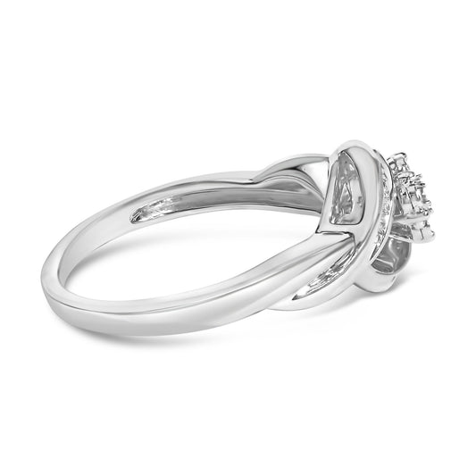 White metal ring shown from a side angle with a crisscross band design, featuring white baguette-shaped gemstones in a channel setting and round white gemstones in a prong setting on the top.