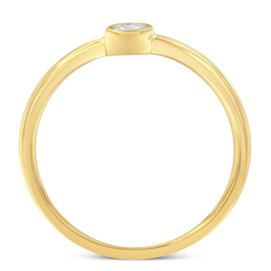 Top-down close-up of a yellow ring with a single round white gemstone in a bezel setting.