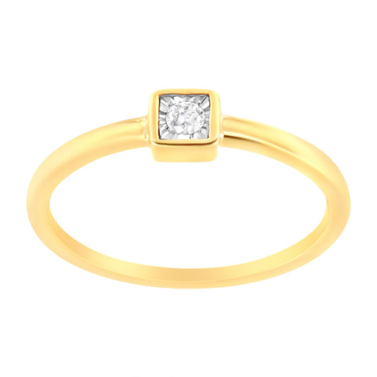 Close-up front angle of a yellow ring with a single round white gemstone in a square setting.