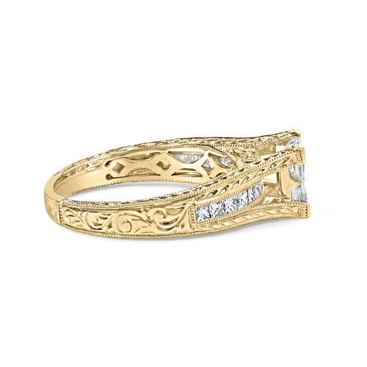 Side angle view of a yellow ring with intricate engraving and white princess shape gemstones in invisible and channel settings along the band.