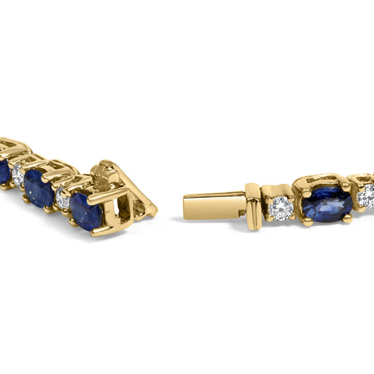Close-up angled view of a yellow metal bracelet featuring alternating blue oval gemstones and white round gemstones in 4-prong settings.