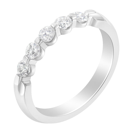 White metal ring with five round white gemstones in a channel setting, shown at a slight angle.