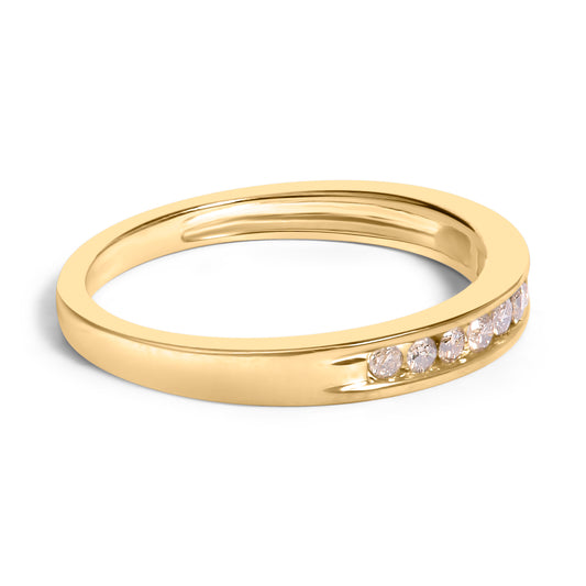 Close-up front angle of a yellow metal ring featuring a row of round white gemstones set in a channel along the band.
