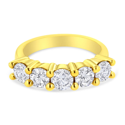 Yellow metal ring with five round white gemstones in prong setting, shown in a front angled close-up.