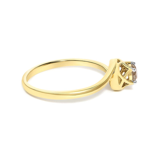 Close-up angled view of a yellow metal ring with a round white gemstone in a prong setting.