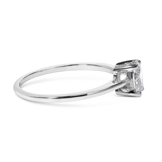Side view of a white metal ring featuring a single oval-shaped white gemstone in a four-prong setting.