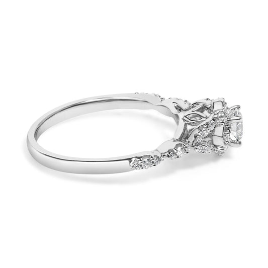 Side angle view of a white metal ring featuring a raised central round white gemstone in four-prong setting, surrounded by multiple smaller round white gemstones in prong settings along the band and decorative elements.
