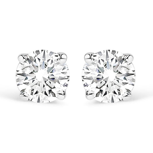 Front-facing close-up of a pair of white stud earrings each set with a round white gemstone in a four-prong setting.