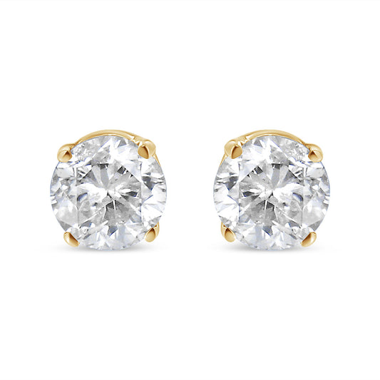 Pair of yellow metal stud earrings with round white gemstones in 4-prong settings, shown from a front angle.