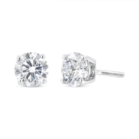 Pair of white metal stud earrings with round white gemstones in four-prong settings, shown from a front and side angle.