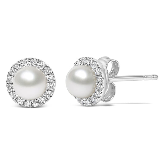 Close-up front and side view of a pair of white stud earrings with a central round white gemstone surrounded by a pave setting of small round white gemstones.