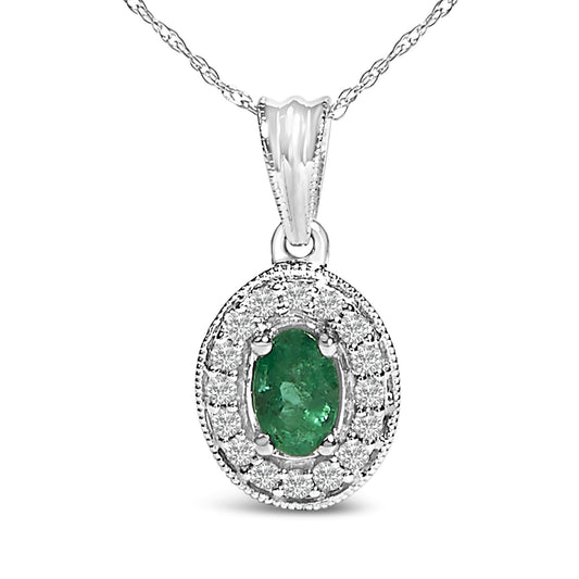 Close-up front view of a white metal necklace featuring an oval green gemstone surrounded by a halo of round white gemstones in prong settings.