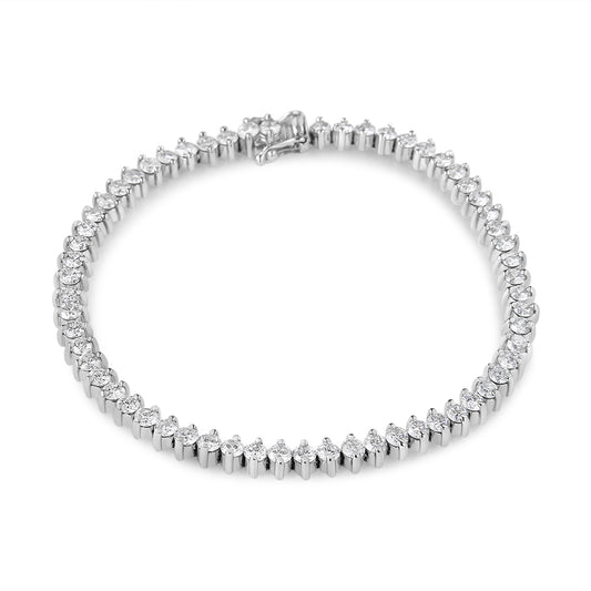 Top-down angled view of a white metal tennis bracelet with round white gemstones in a two-prong setting.