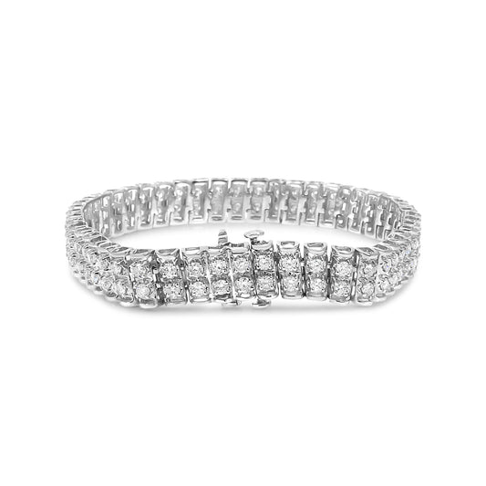 Close-up front angle of a white metal bracelet with multiple rows of round white gemstones in prong settings.