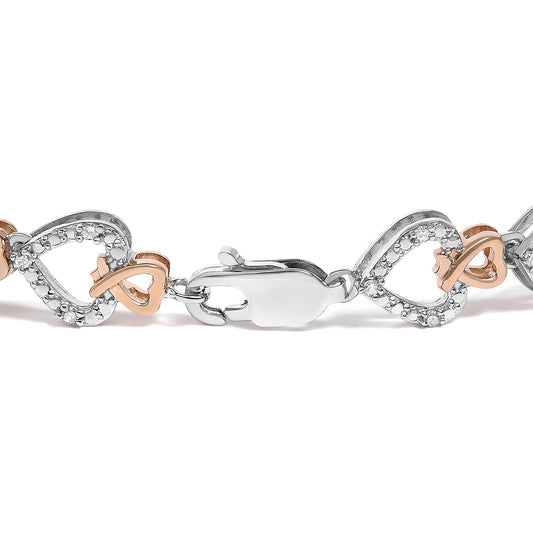 Close-up front angle of a bracelet featuring linked heart shapes in white and rose metal colors with white round gemstones in a pave setting, shown against a white background.