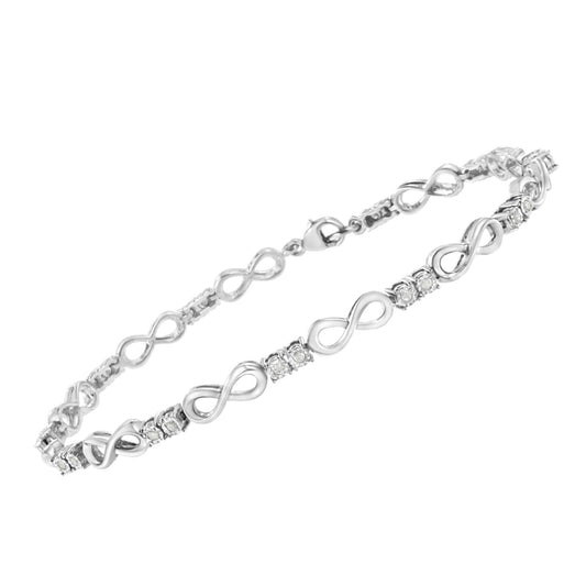White metal bracelet with alternating infinity-shaped links and clusters of round white gemstones in miracle setting, shown in a side-angle view.