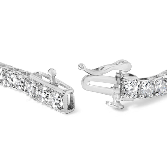 Close-up shot of a white metal bracelet with round white gemstones in 4-prong settings, shown laying flat with the clasp open.