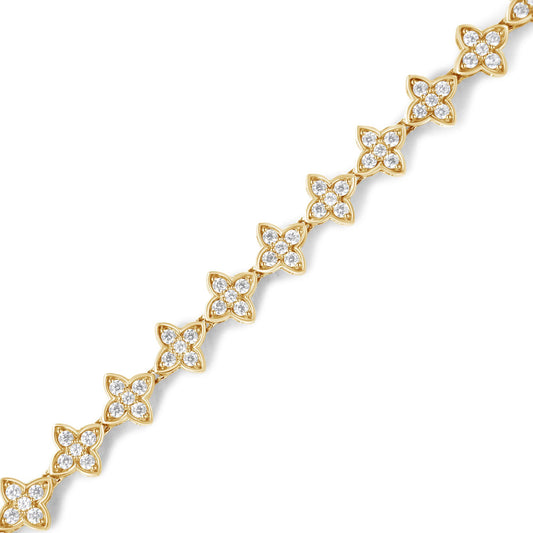Diagonal close-up of a yellow bracelet featuring floral-shaped links adorned with white round gemstones in prong settings.