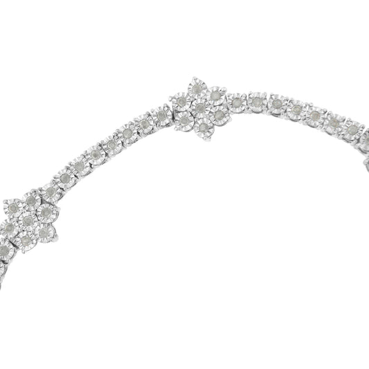 Close-up front angle of a white metal bracelet with a row of round white gemstones arranged in a floral pattern.