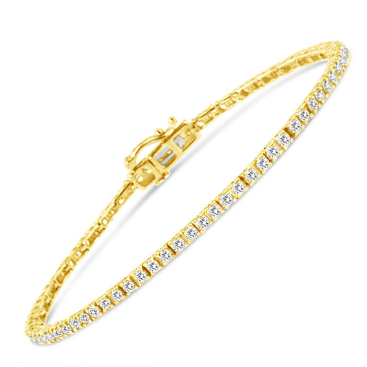Yellow metal bracelet with round brownish gemstones in prong setting, shown at an angled close-up.