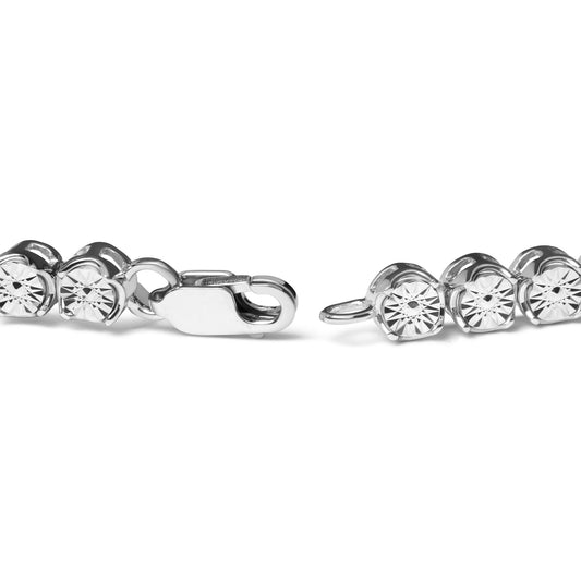 Close-up, horizontal view of a white metal bracelet with round white gemstones in a miracle setting and a lobster clasp, displayed against a white background.
