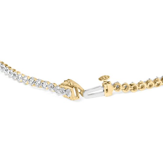 Close-up front angle of yellow bracelet with round white gemstones in prong settings along its length, showing the open clasp.