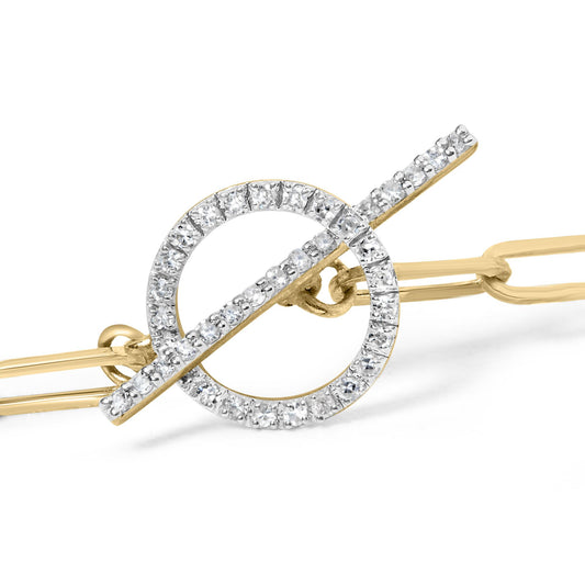 Close-up side angle of a yellow metal bracelet featuring a circular and bar toggle clasp adorned with white round gemstones in prong settings.