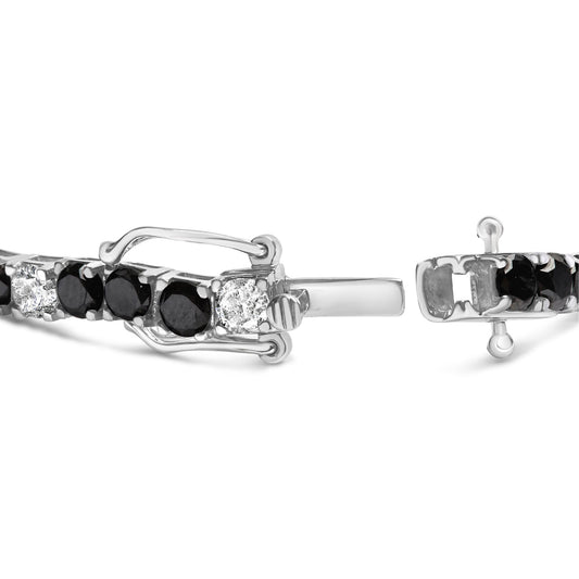 Close-up front angle of a white metal bracelet with alternating round white and black gemstones in four-prong settings, showing the clasp details.