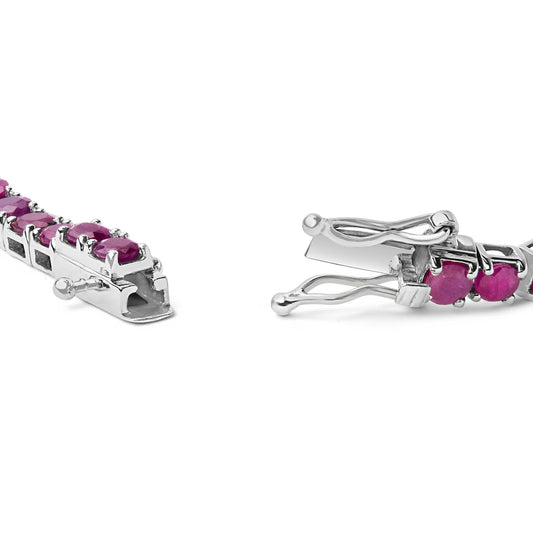 Close-up front angle of a white metal bracelet with pink round gemstones in four-prong settings, focusing on the open clasp.