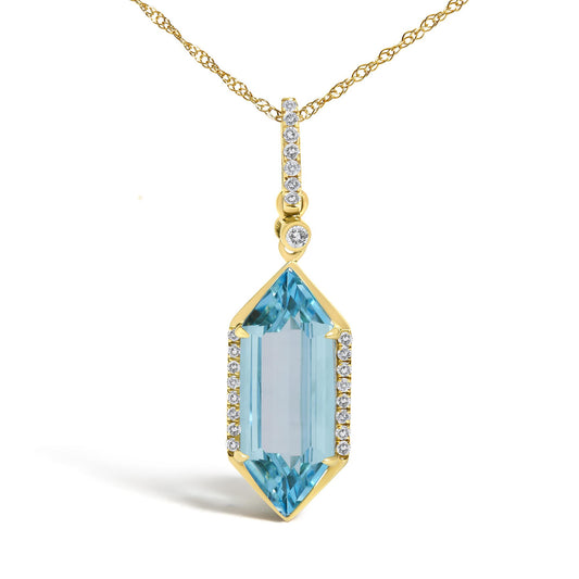 Close-up front view of a yellow metal necklace with a vertically aligned pendant featuring round white gemstones in micro-pave setting along the top and sides, and a large blue gemstone in a prong setting at the bottom.