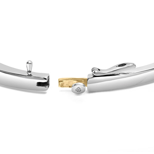 Close-up front angle of a bracelet clasp showing yellow and white metal with a secure locking mechanism.