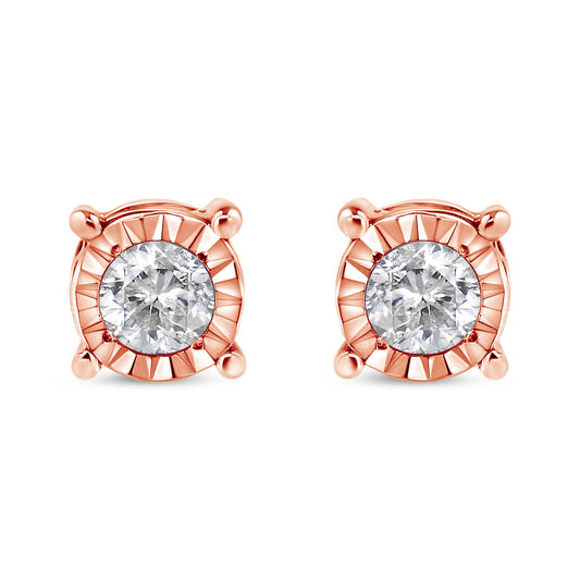 Front view of a pair of rose metal stud earrings each featuring a round white gemstone with a miracle setting.
