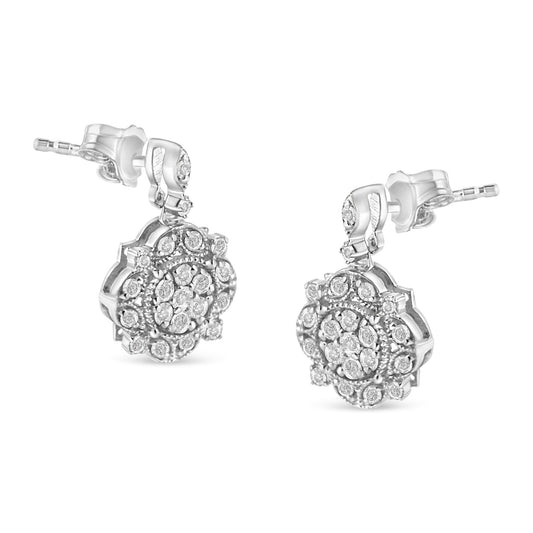Pair of white metal drop earrings with round white gemstones in prong settings, photographed from a front angled view.