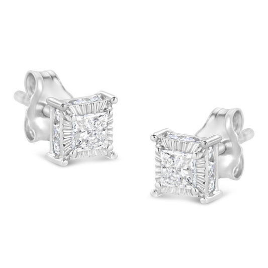 Pair of white metal stud earrings with princess shape white gemstones in the center surrounded by smaller round white gemstones on all sides, shown from an angled front view.