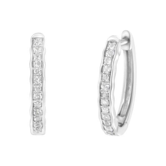 Front and angled view of white metal hoop earrings with a row of small round white gemstones in a pave setting.