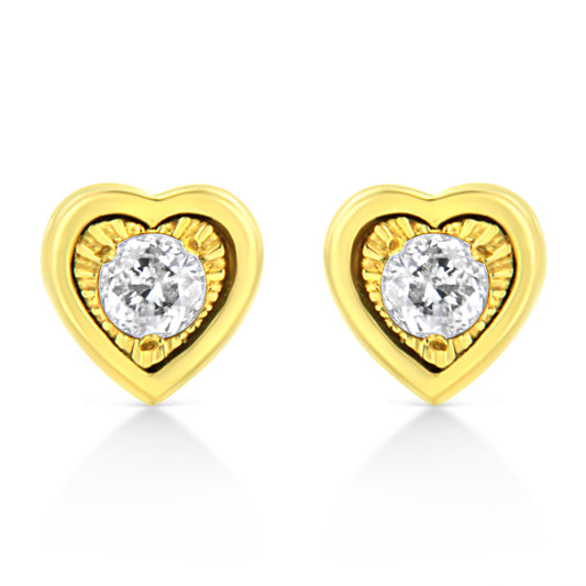 Front-facing shot of yellow metal heart-shaped earrings each set with a round white gemstone in a miracle setting with brownish accents.