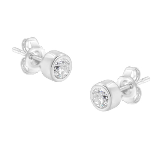 Pair of white metal stud earrings with round white gemstones in bezel settings, shown from a slightly angled front view.