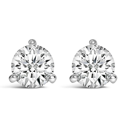 Front-facing shot of a pair of white metal stud earrings, each featuring a round white gemstone in a three-prong setting.