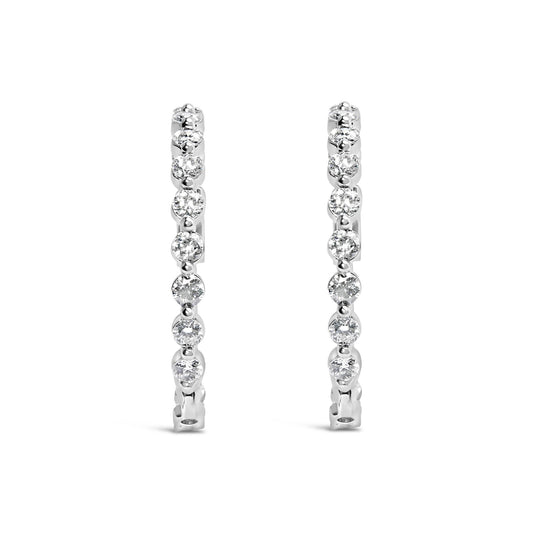 Front-facing view of a pair of white-colored metal hoop earrings, each adorned with a row of round white gemstones in 2-prong settings.