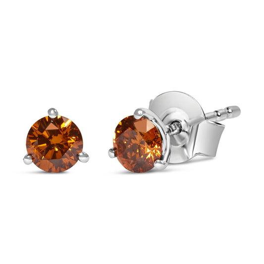 Pair of white metal stud earrings with round orange gemstones in three-prong settings, shown from a slightly angled front and side view.