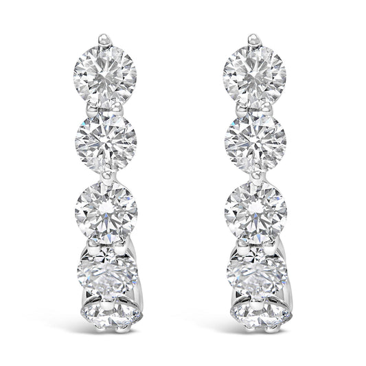 Front view of white metal earrings featuring a vertical row of round white gemstones in prong settings.