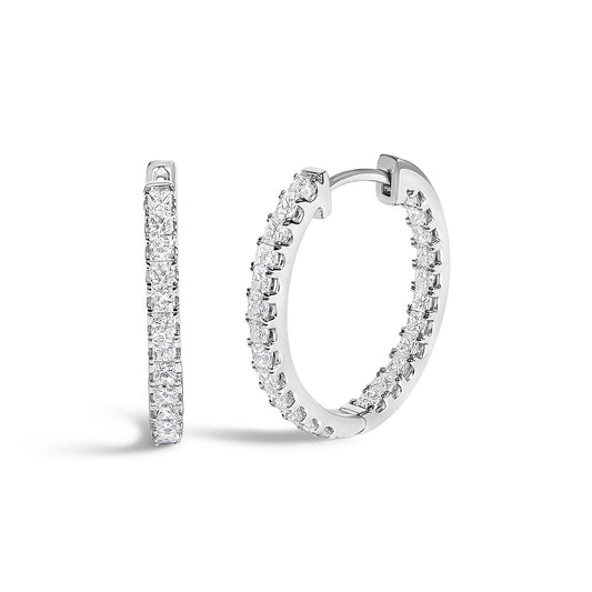 Close-up front angle of a pair of white hoop earrings featuring princess-shaped white gemstones in prong settings along the outer edge.