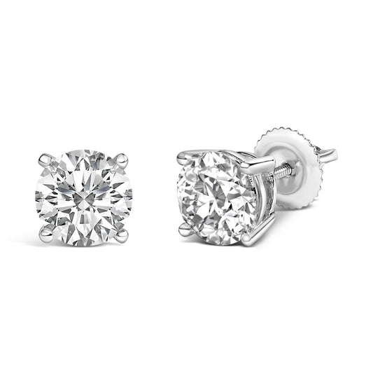 Pair of white metal stud earrings with round white gemstones in four-prong settings, one shown from the front and the other at a side angle.
